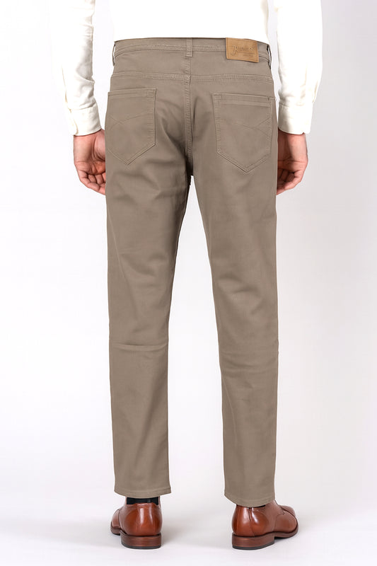 Beige pants worn by a person on a white background