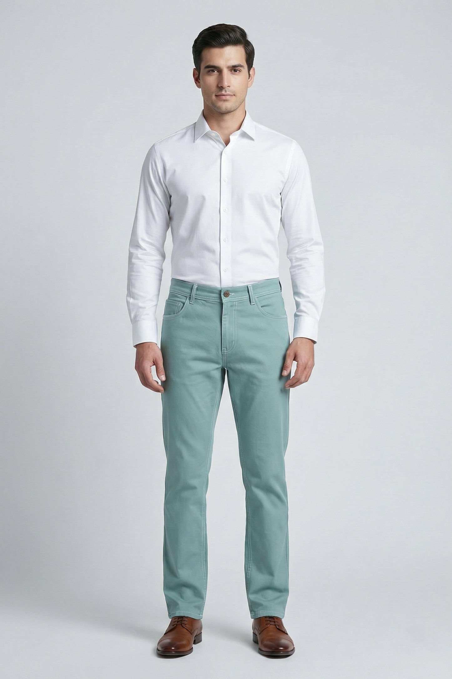 Man wearing a white dress shirt and light green pants on a gray background