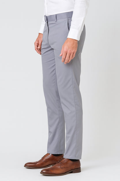 Gray dress pants worn with a white shirt and brown shoes on a white background