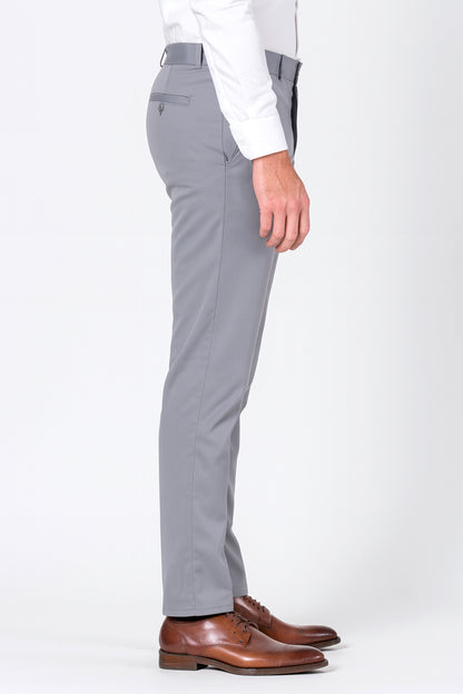 Gray pants worn with a white shirt and brown shoes on a white background
