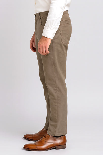 Person wearing brown pants and brown shoes on a white background