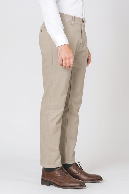 Beige pants worn with a white shirt and brown shoes on a white background