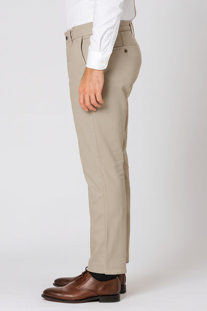 Beige pants worn with a white shirt and brown shoes on a white background