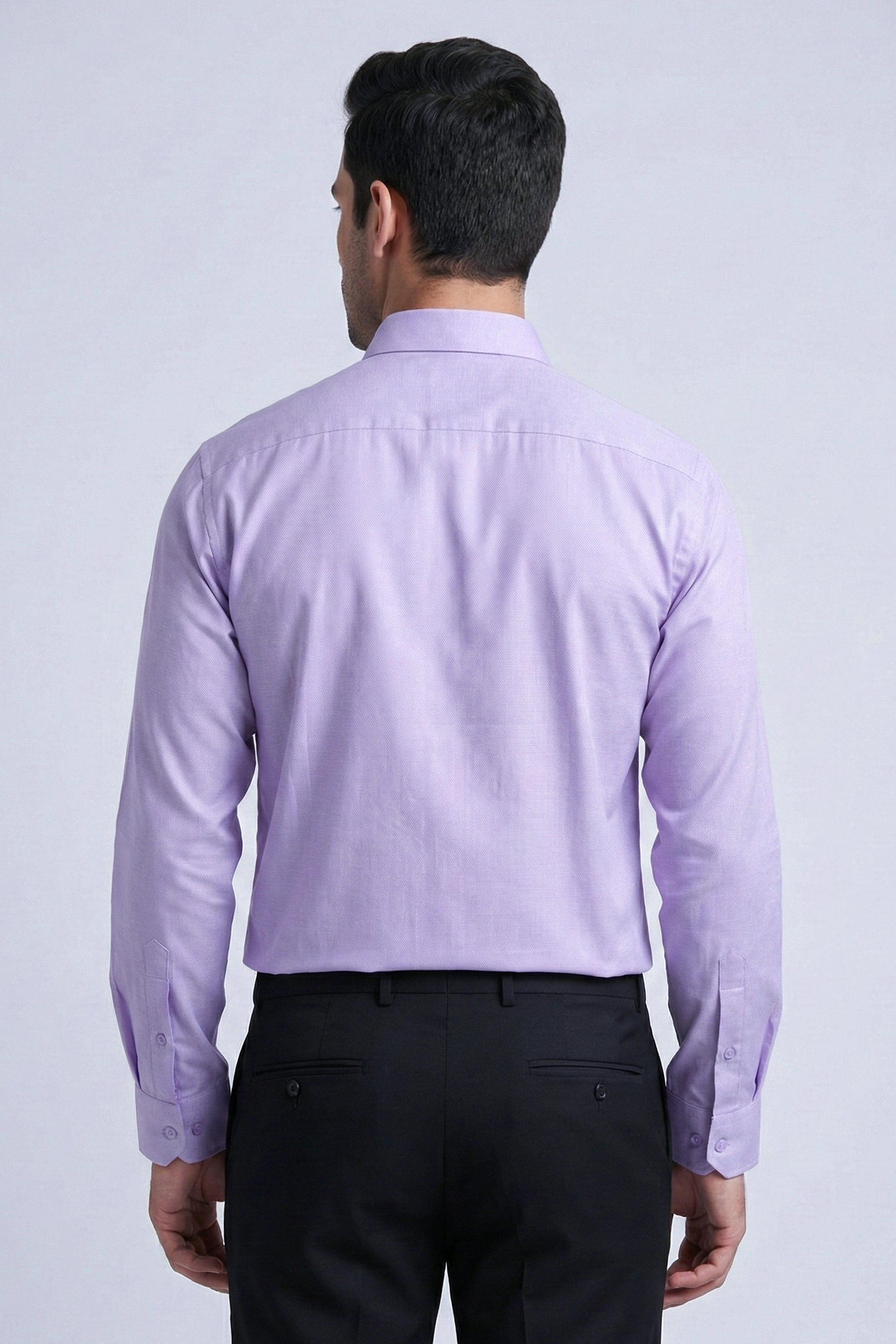 Man wearing a light purple dress shirt and black pants on a white background