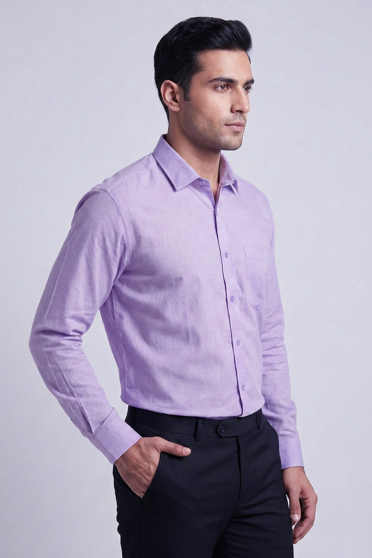 Man wearing a light purple dress shirt and black pants on a light gray background