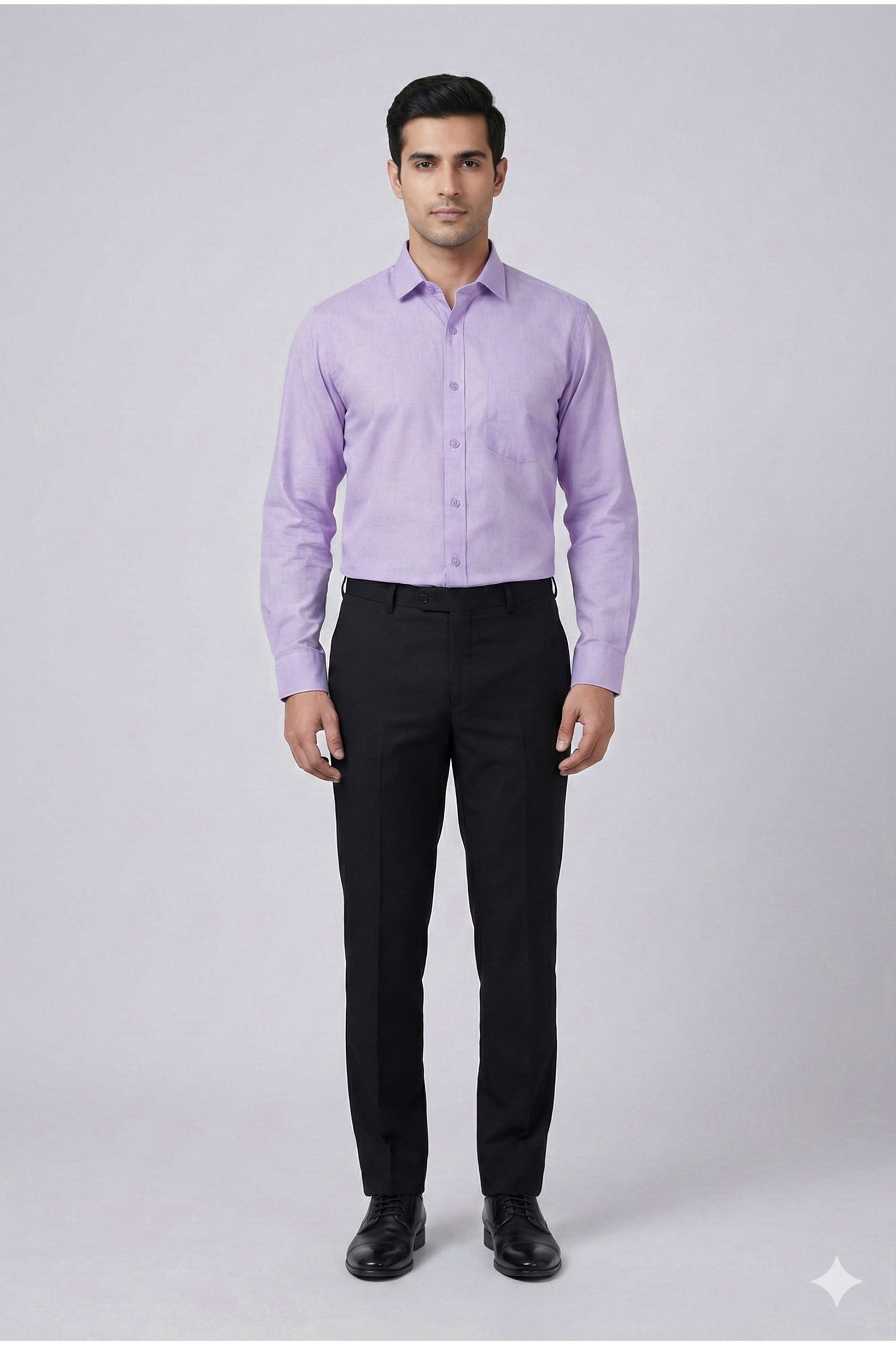 Man wearing a light purple dress shirt and black pants on a gray background