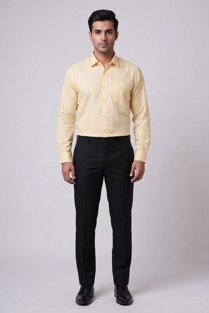 Man wearing a light yellow shirt and black pants on a white background