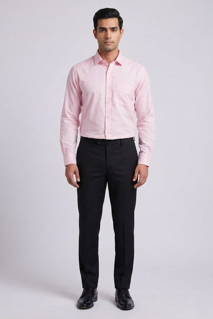 Man wearing a pink dress shirt and black pants on a white background