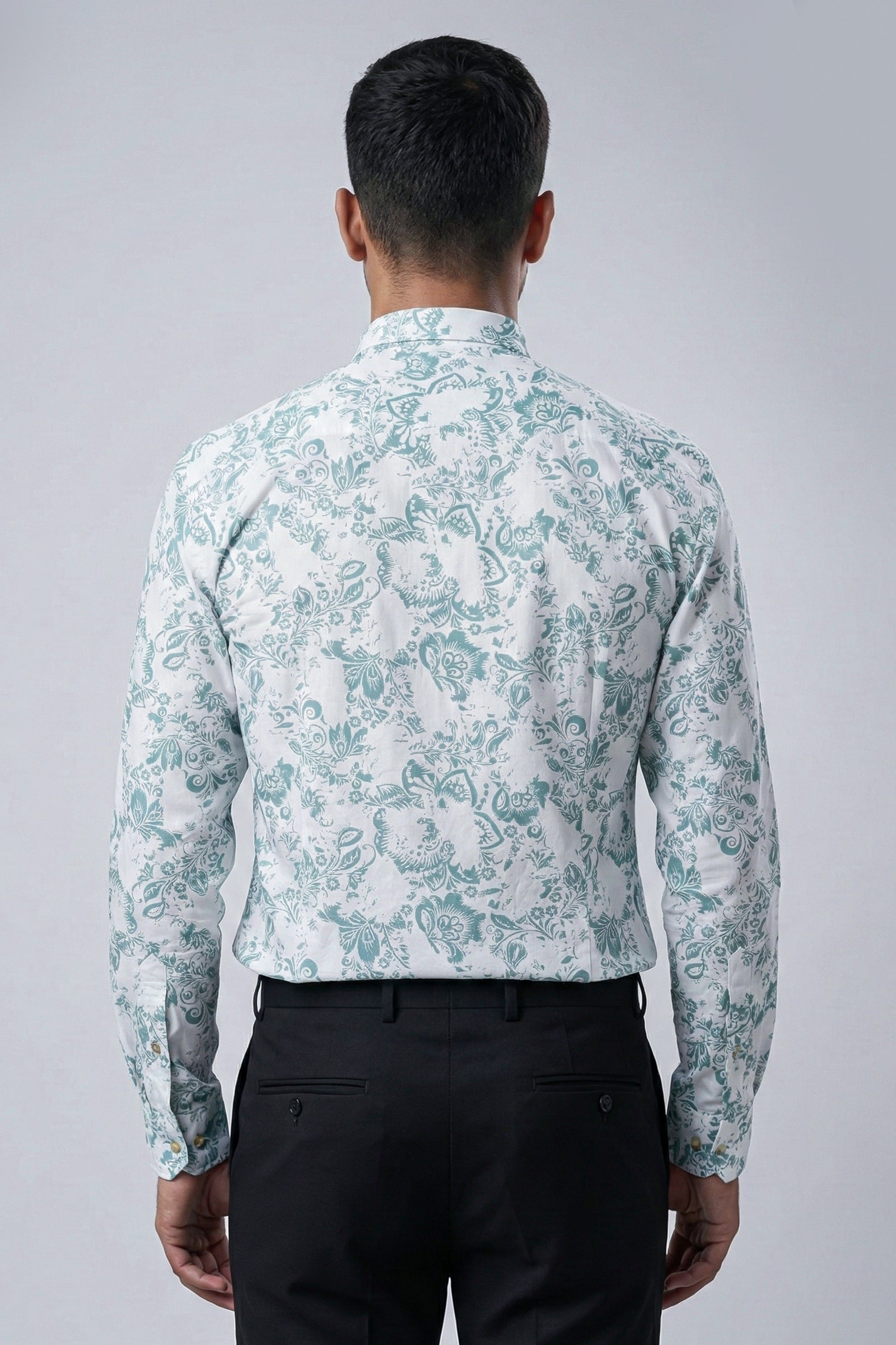 Man wearing a light blue floral patterned shirt on a gray background