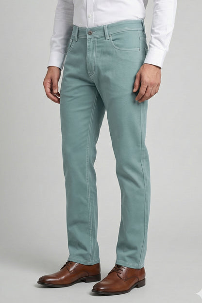 Person wearing light blue jeans and brown shoes on a plain background