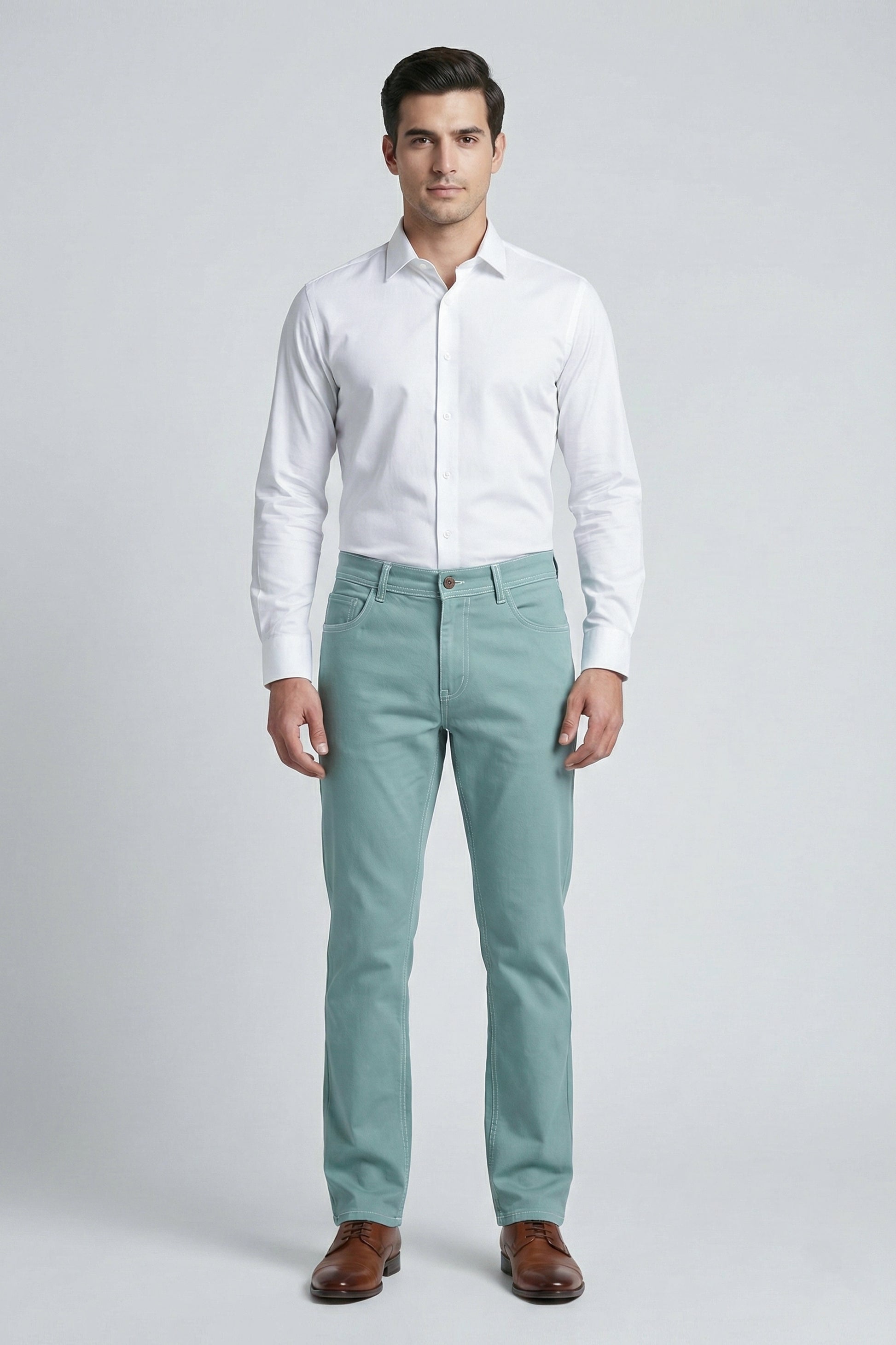 Man wearing a white dress shirt and light green pants on a gray background