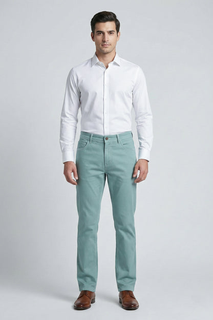 Man wearing a white dress shirt and light green pants on a gray background