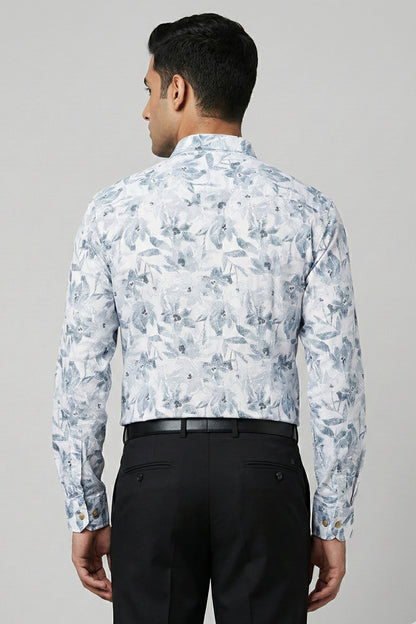 Man wearing a floral patterned shirt and black pants on a gray background