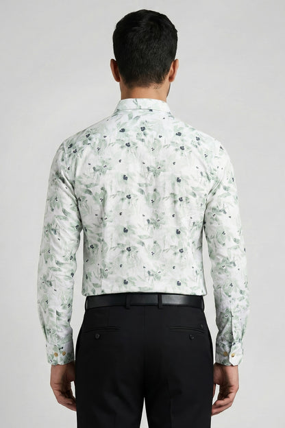 Man wearing a floral shirt and black pants on a plain background