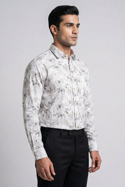 Man wearing a white floral patterned shirt and black pants on a gray background