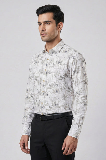 Man wearing a patterned shirt and black pants on a gray background