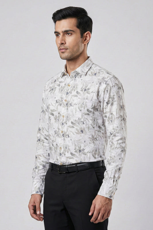 Man wearing a patterned shirt and black pants on a gray background