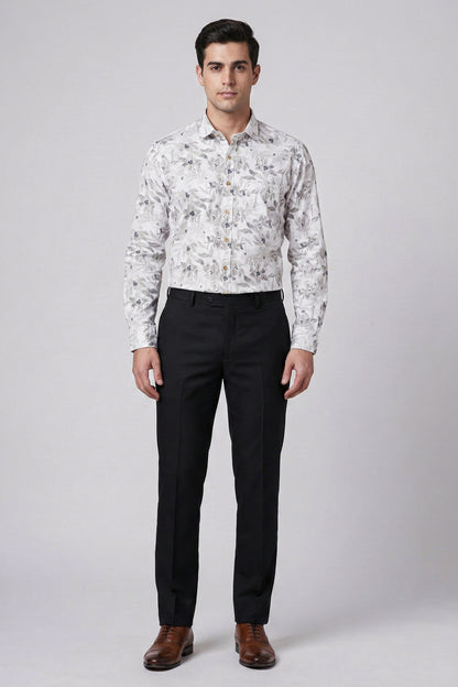 Man wearing a floral shirt and black pants on a gray background