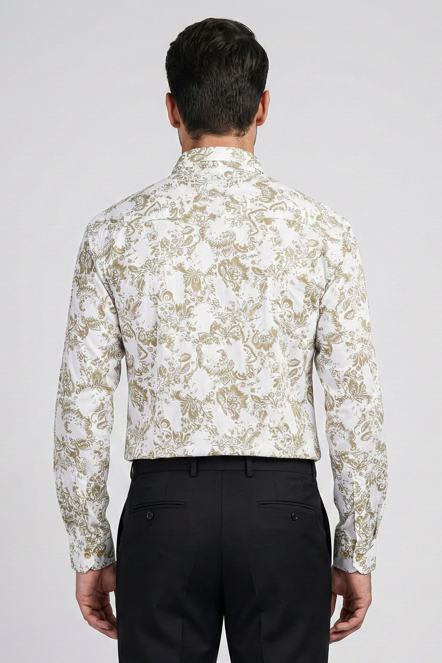 Man wearing a white floral patterned shirt and black pants on a light gray background