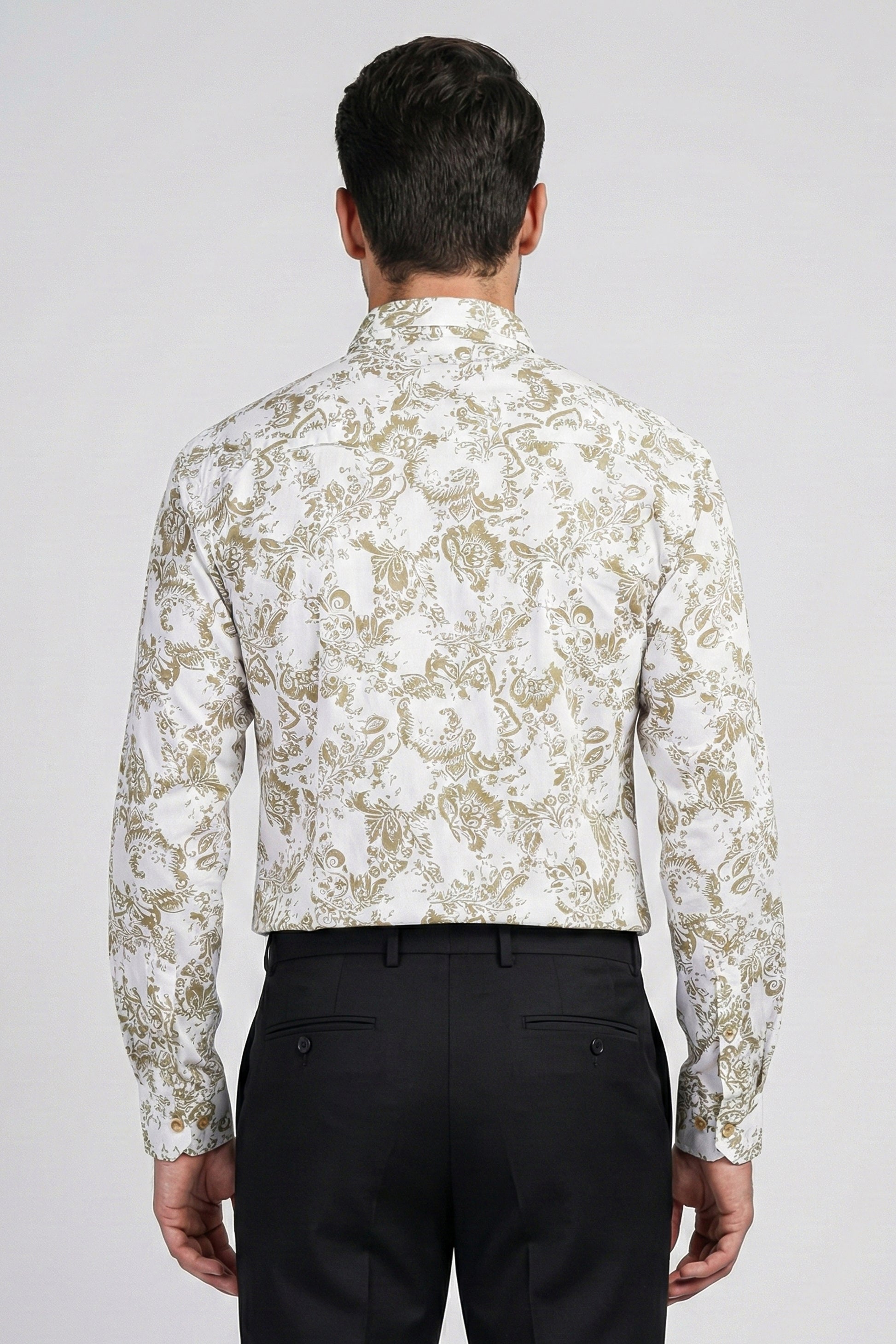 Man wearing a white floral patterned shirt and black pants on a light gray background