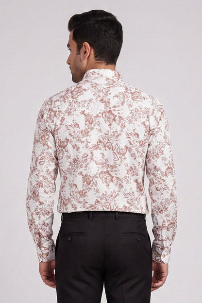 Man wearing a white floral patterned shirt and black pants on a plain background
