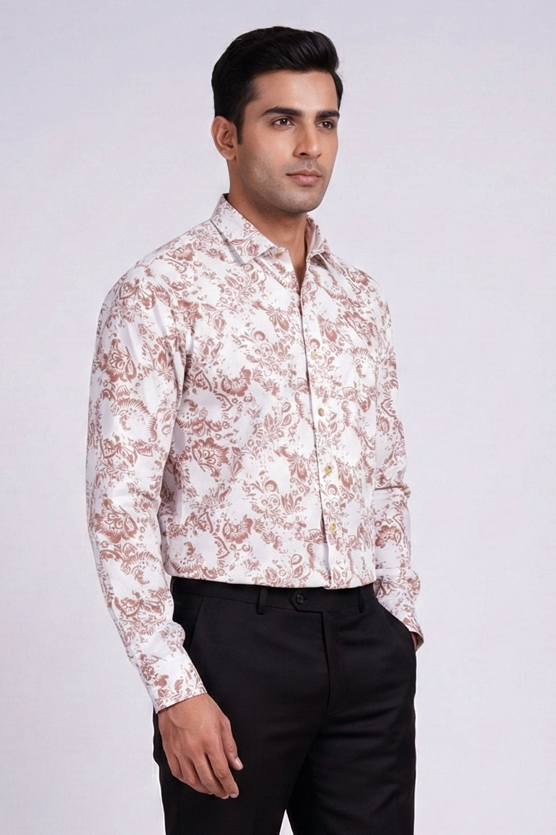Man wearing a patterned shirt and black pants on a white background
