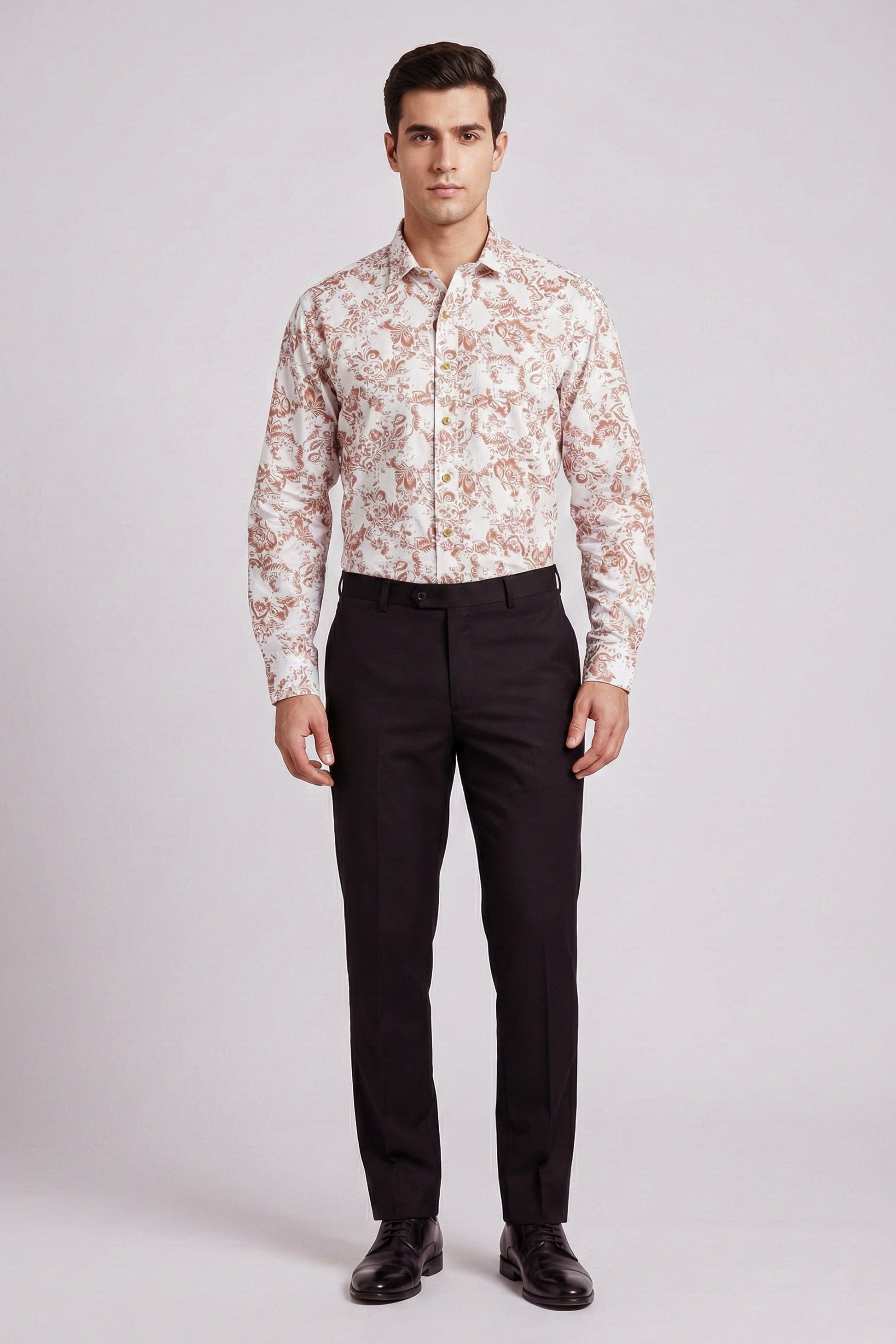 Man wearing a patterned shirt and black pants on a light gray background