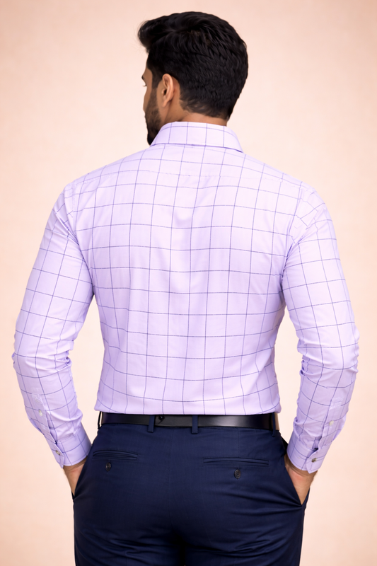 Man wearing a light purple checkered shirt and dark blue pants on a beige background