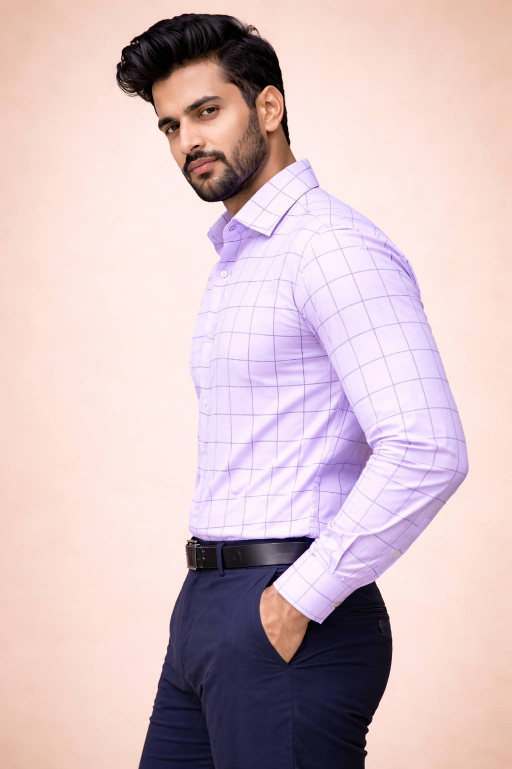 Man wearing a light purple checkered shirt and dark pants on a beige background